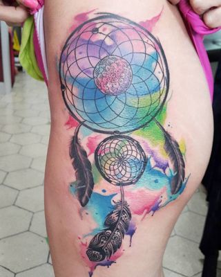 Tatouage attrape rêve avec un effet taches de coleurs sur la hanche et le haut de la cuisse